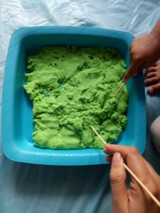 Using sticks with kinetic sand